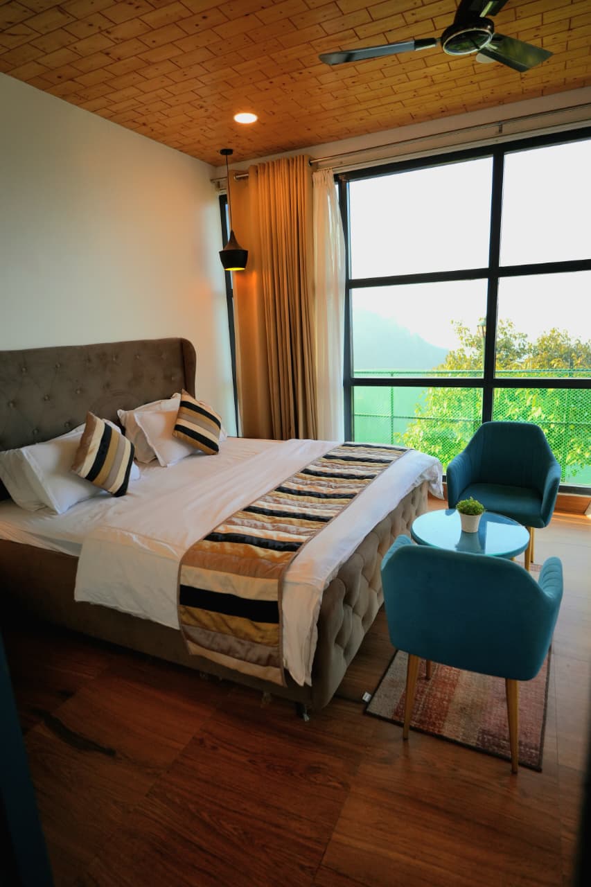 Villa room interior — wooden ceiling, tufted headboard and valley view
